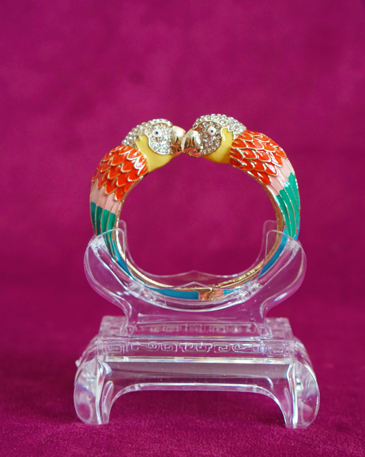 Hinged enamel bangle with two parrots meeting beak to beak, heads paved in sparkling crystals