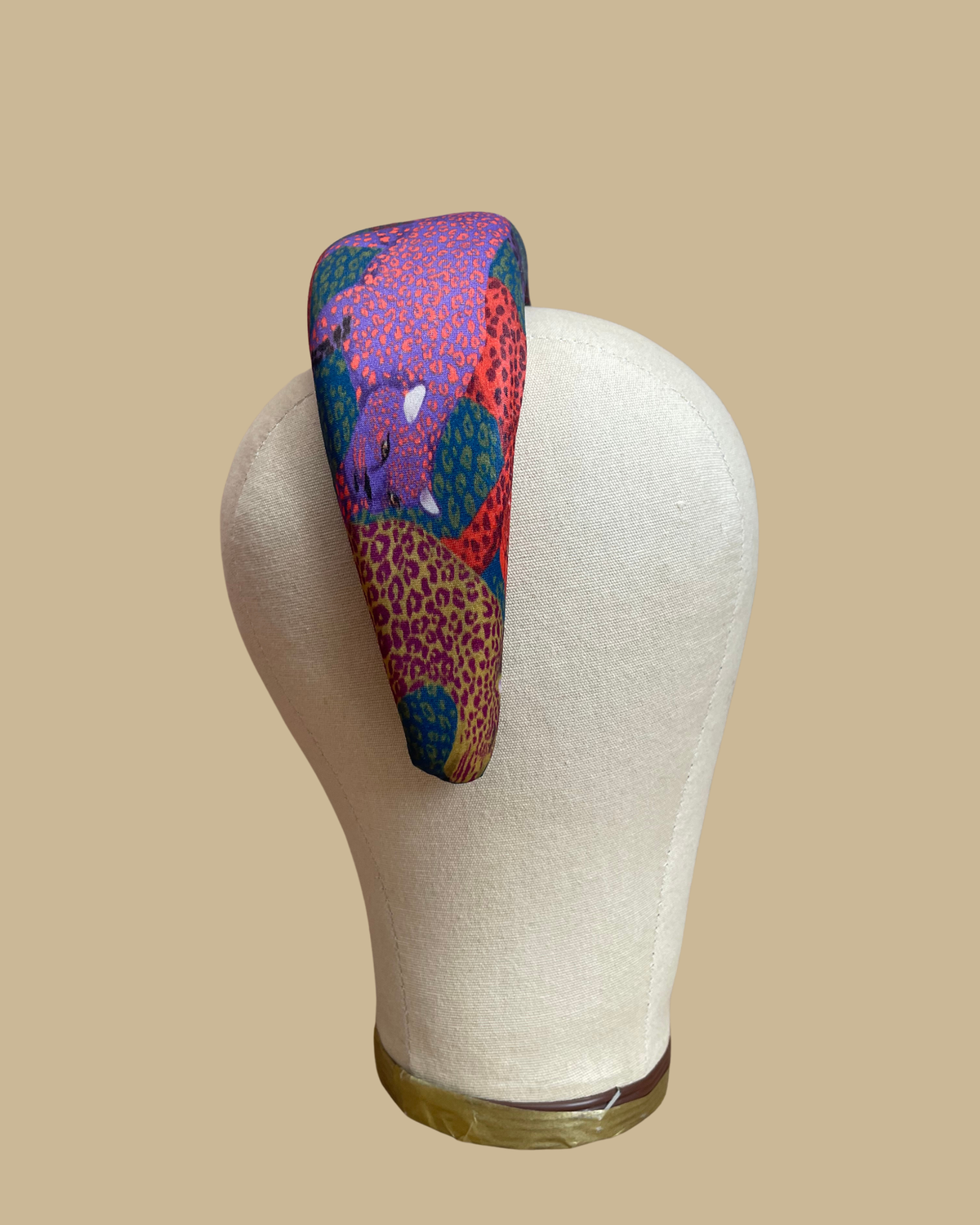 Wide padded Farm Rio headband in a patchwork of jewel-toned leopards in purple, red, teal, and olive
