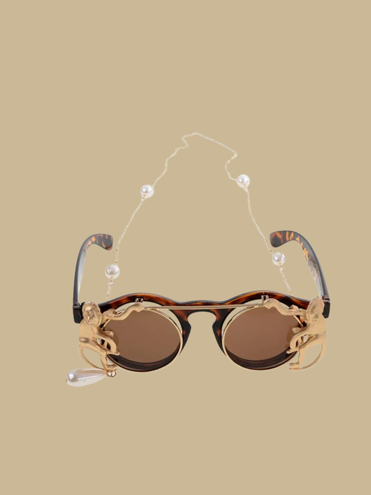 Vintage-inspired flip-up round sunglasses in tortoise shell finish with golden monkey details and a pearl drop