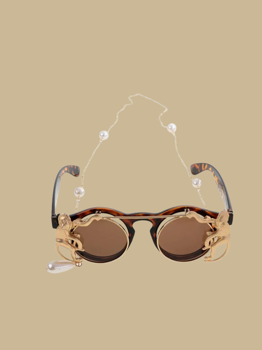 Vintage-inspired flip-up round sunglasses in tortoise shell finish with golden monkey details and a pearl drop