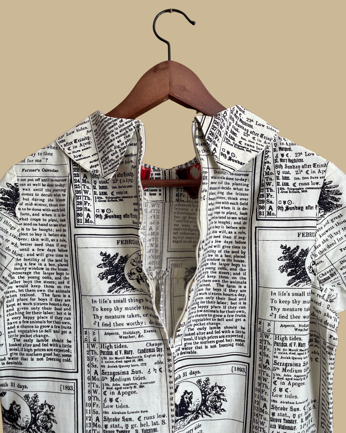 A vintage handmade shift dress with an apple and farmer's-almanac newspaper print, shown against a kraft background