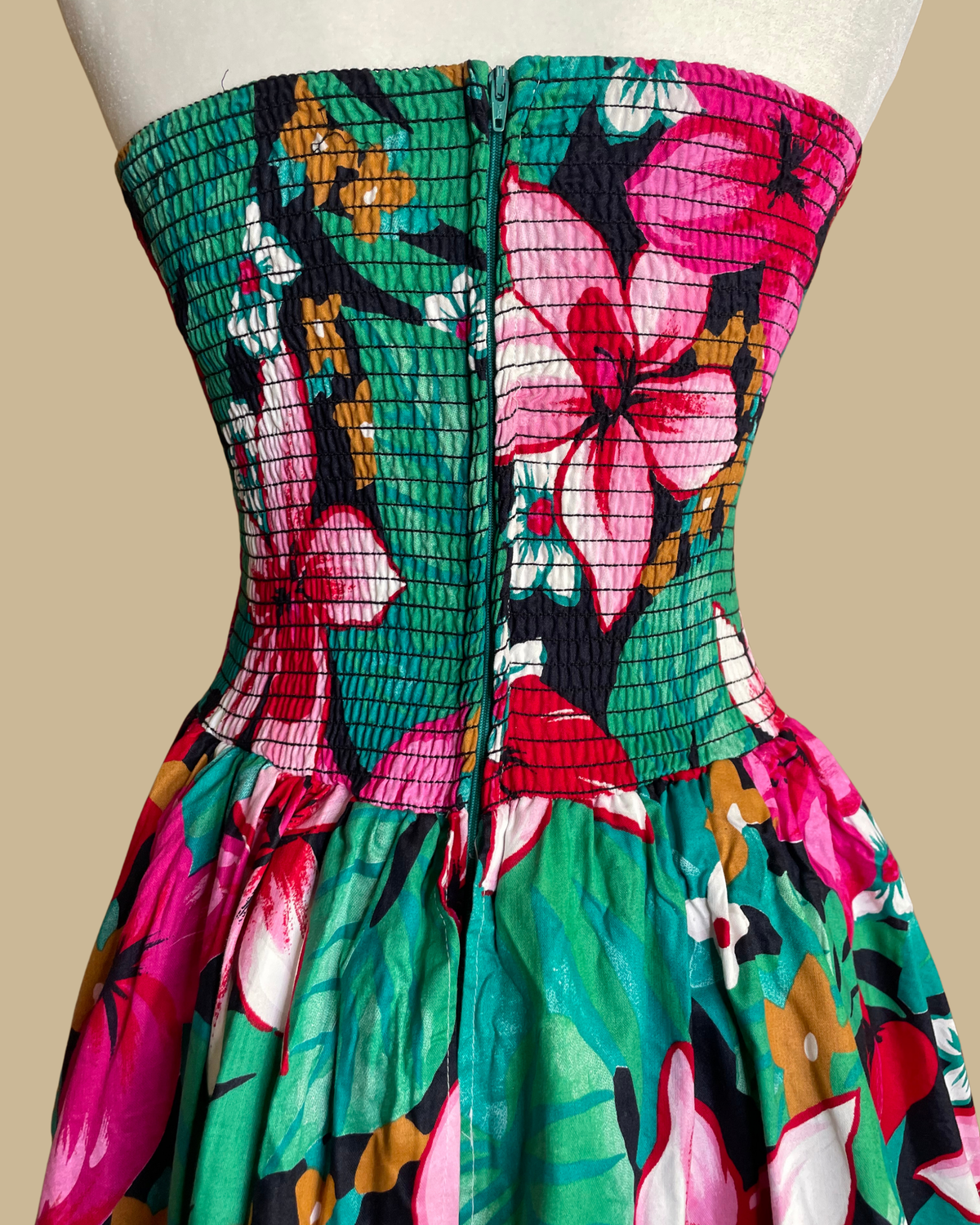 Close-up of the Robbie Bee brand label on the tropical floral strapless dress