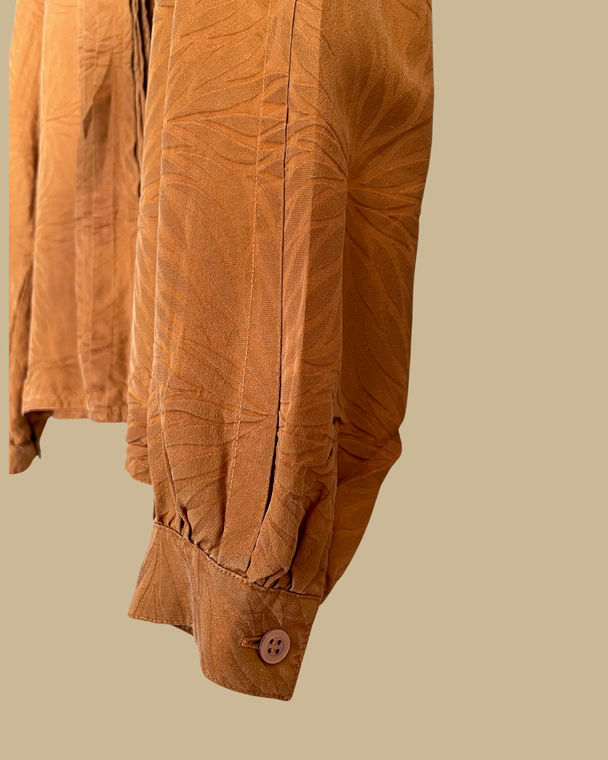 Close-up of the pintuck front detail on the rust jacquard blouse