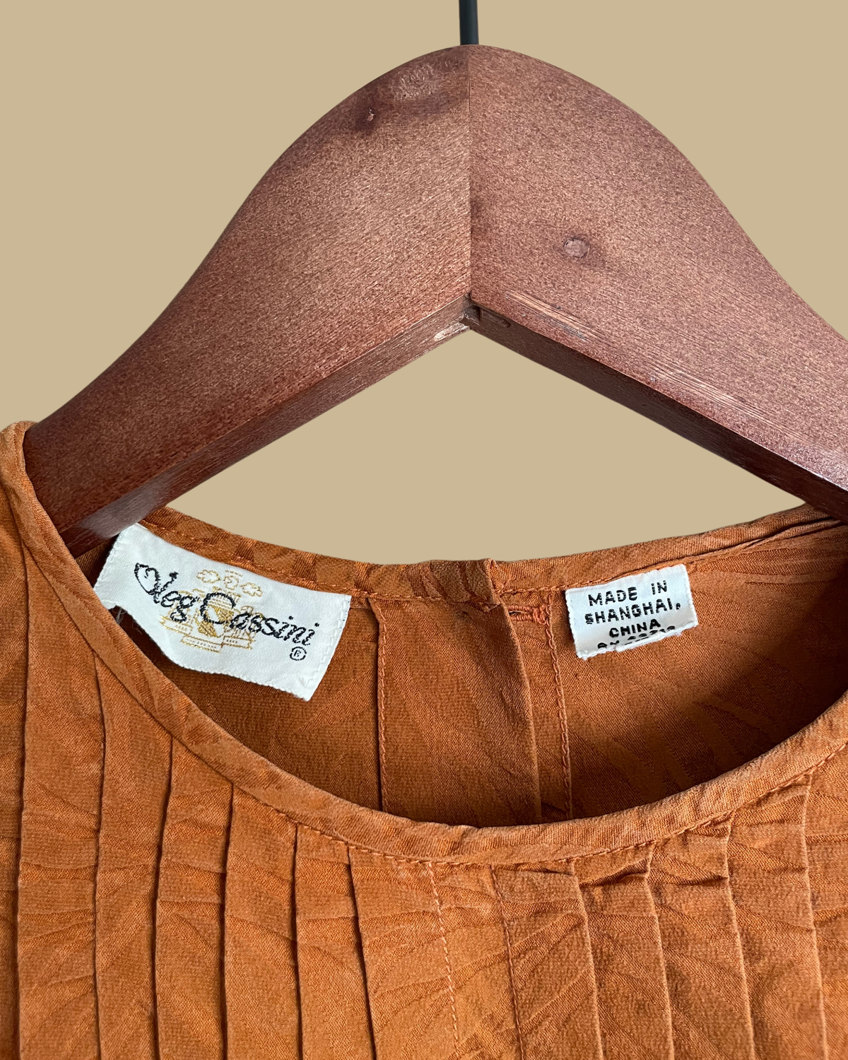 Close-up of the subtle jacquard leaf print fabric texture on the rust blouse