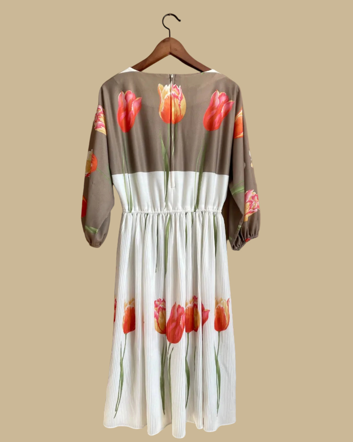 A vintage Herman Marcus tulip print dress in a taupe and cream colorblock with dolman sleeves, shown against a kraft background