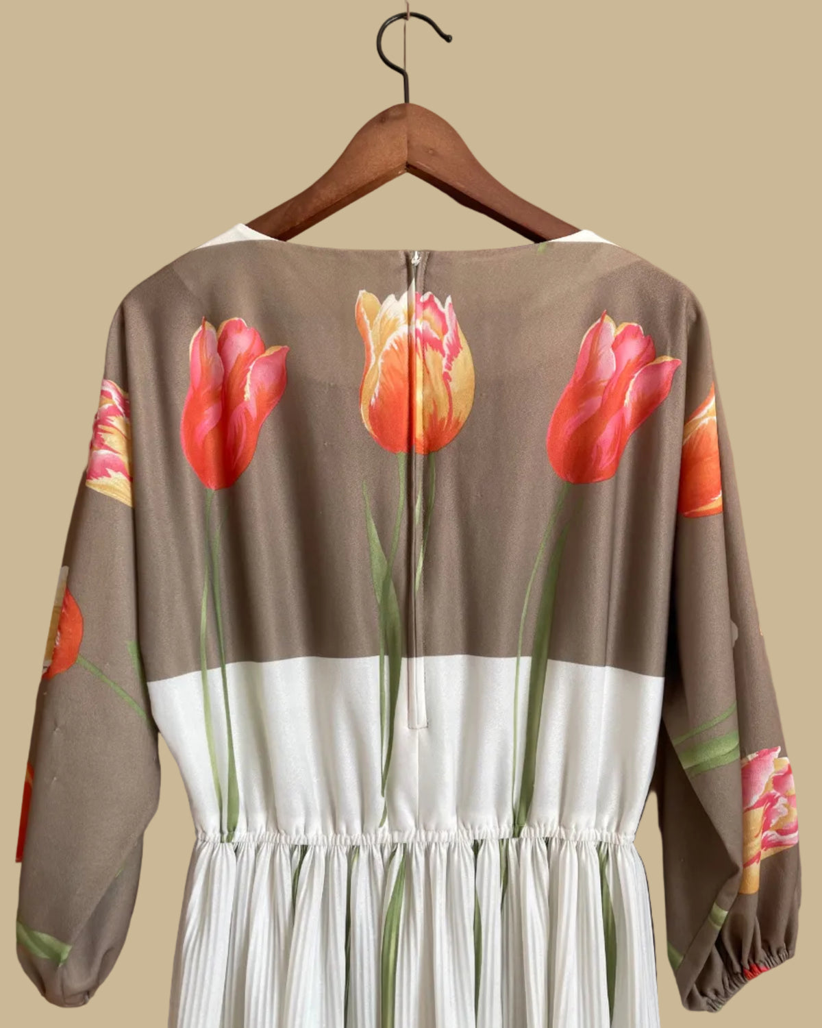 A vintage Herman Marcus tulip print dress in a taupe and cream colorblock with dolman sleeves, shown against a kraft background