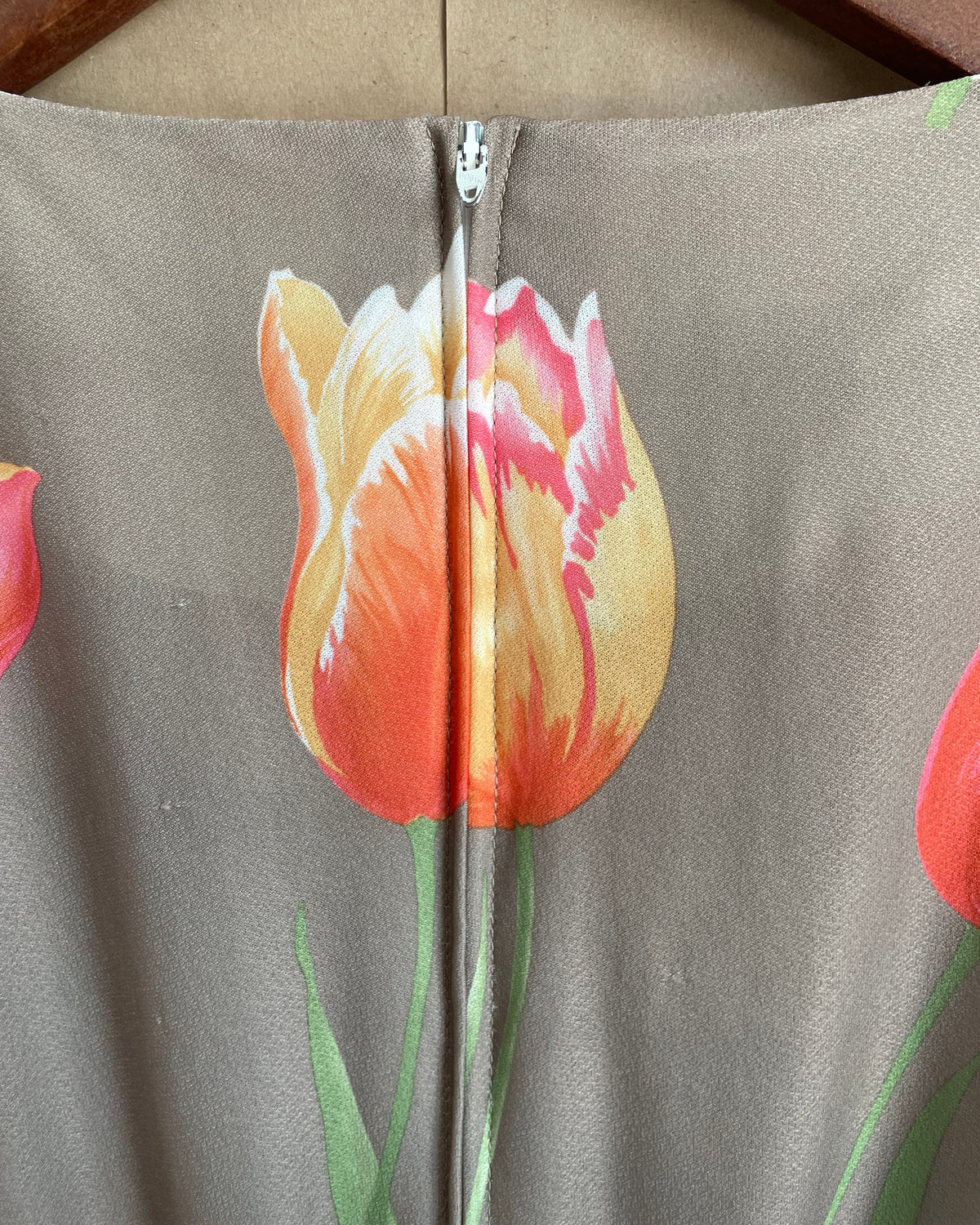 A vintage Herman Marcus tulip print dress in a taupe and cream colorblock with dolman sleeves, shown against a kraft background