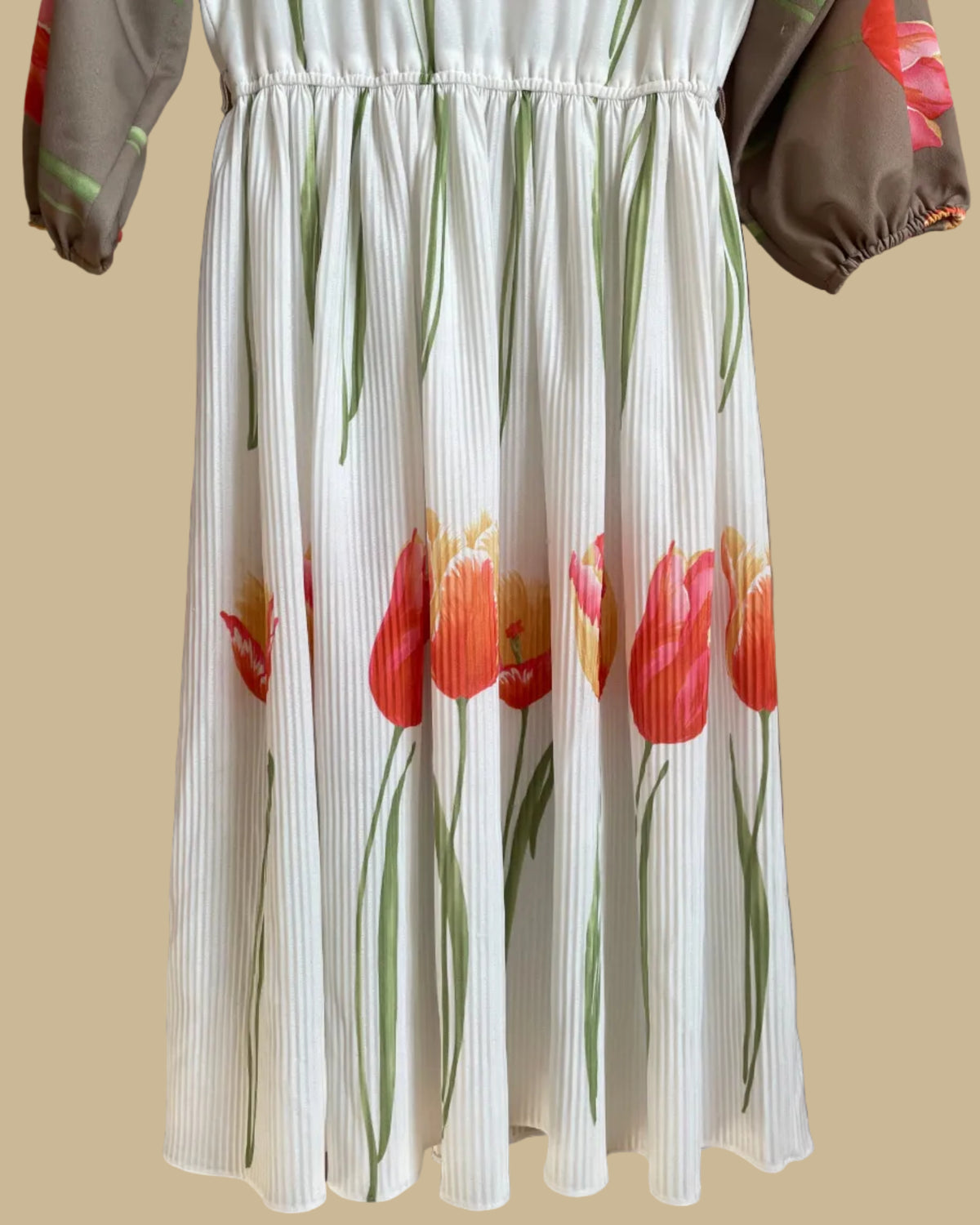 A vintage Herman Marcus tulip print dress in a taupe and cream colorblock with dolman sleeves, shown against a kraft background