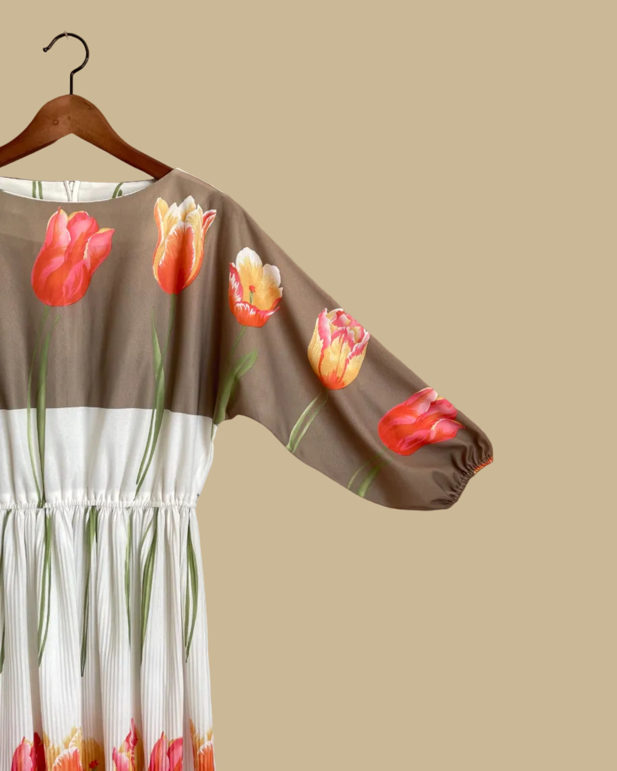 A vintage Herman Marcus tulip print dress in a taupe and cream colorblock with dolman sleeves, shown against a kraft background