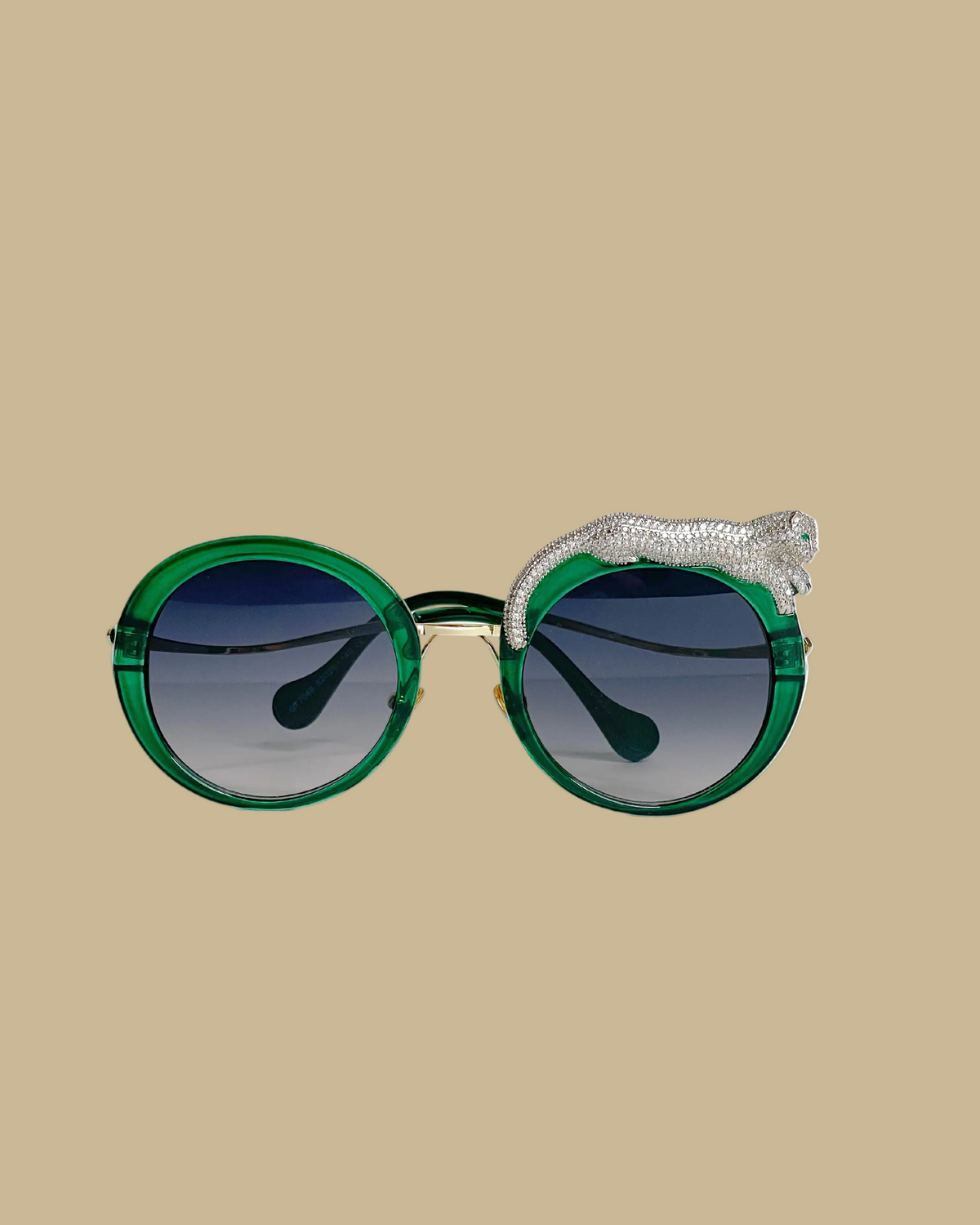 Retro-style sunglasses with a jeweled leopard figure lounging on one side, featuring emerald green jeweled eyes, in a malachite green colorway