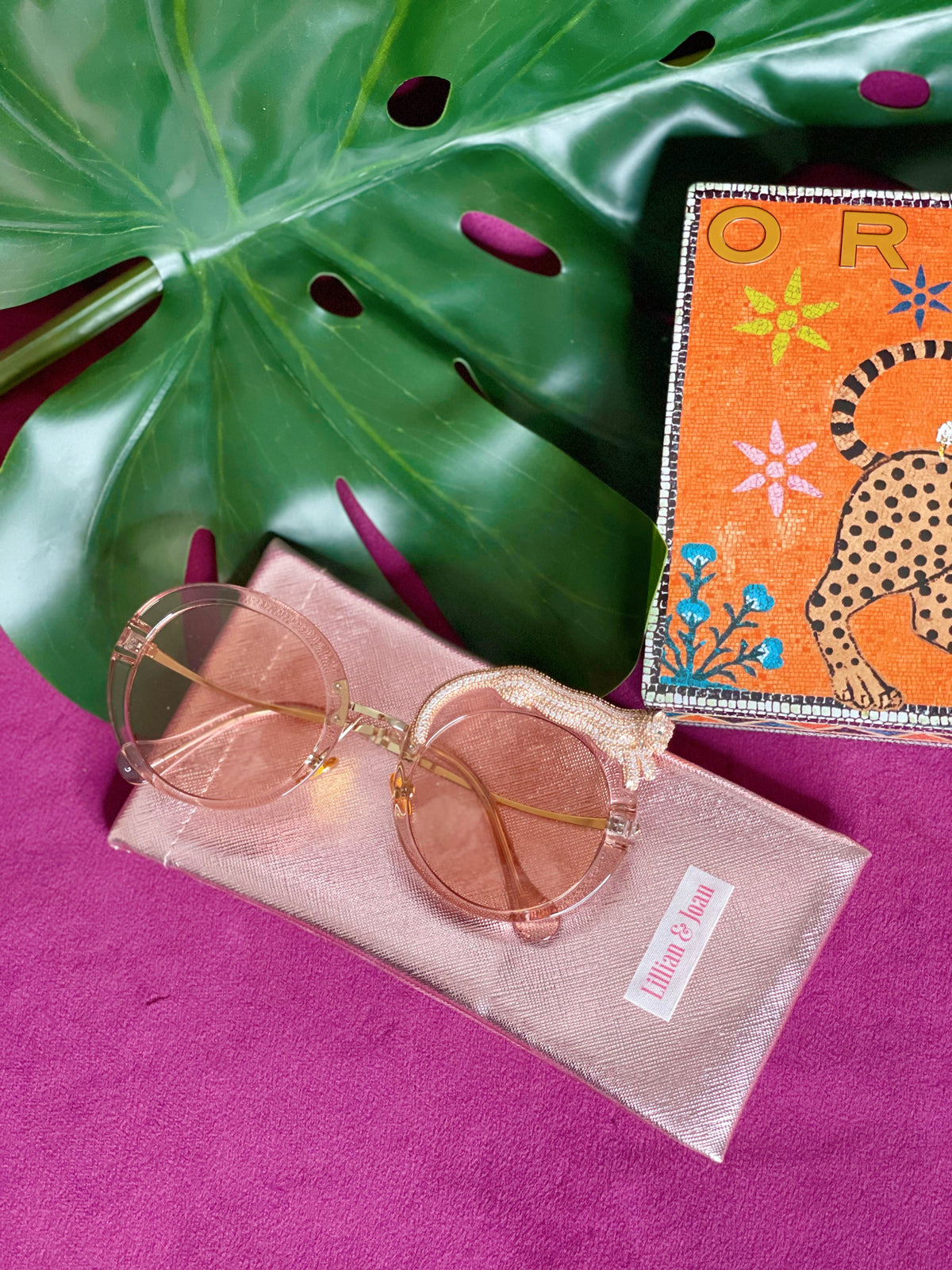 Fierce Feline Rosé Champagne sunglasses shown with the custom L&J metallic pouch